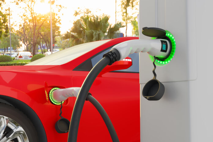 Electric vehicle power plugged charging at station with load indicator lights, Technology smart car concept Il parco installato delle colonnine di ricarica sta aumentando la qualità di connessione dell'infrastruttura e la SIM card è una risposta