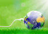 Green Lab: tecnologie, incentivi e partnership per l’elettrificazione urbana. A Milano il 24 febbraio Green energy concept with Planet Earth and electric plug on lush grass