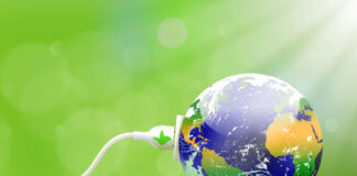 Green Lab: tecnologie, incentivi e partnership per l’elettrificazione urbana. A Milano il 24 febbraio Green energy concept with Planet Earth and electric plug on lush grass