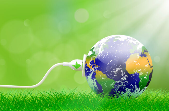 Green Energy Plug Green energy concept with Planet Earth and electric plug on lush grass